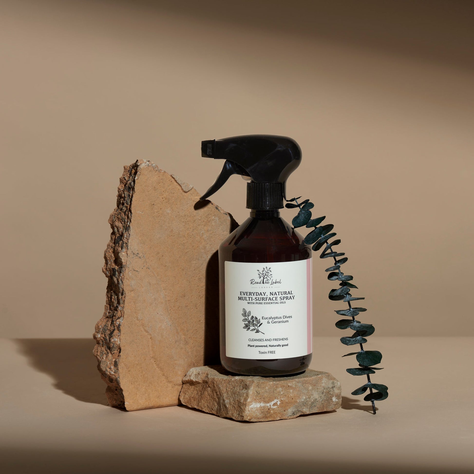 Natural multi-surface cleaner by Read The Label London with eucalyptus and geranium, showing spray bottle and fresh ingredients.