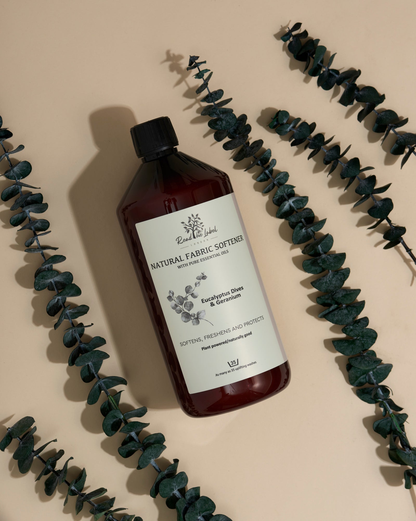 Natural fabric softener by Read The Label London with eucalyptus and geranium, showing a soft fabric and botanical scent elements.